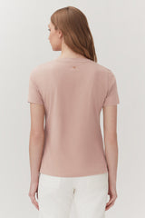 Woman seen from behind, wearing a short-sleeved top and pants, standing upright.