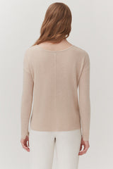 Woman pictured from behind, wearing a sweater and pants.