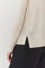 Person wearing sweater and trousers, cropped at the waist.