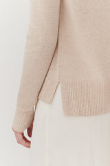 Close-up of a person wearing a sweater and skirt.