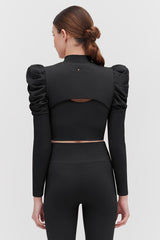 Woman viewed from behind wearing an outfit with puffed sleeves and back cut-out.