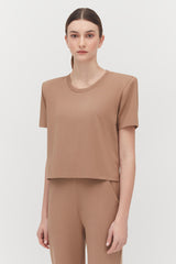 Woman in a crew neck t-shirt and matching pants, standing.