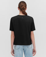 Woman in a t-shirt and jeans viewed from the back.