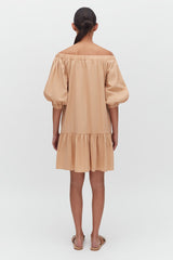 Woman in a dress standing with her back facing the camera.