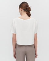 Woman standing with her back facing the camera.