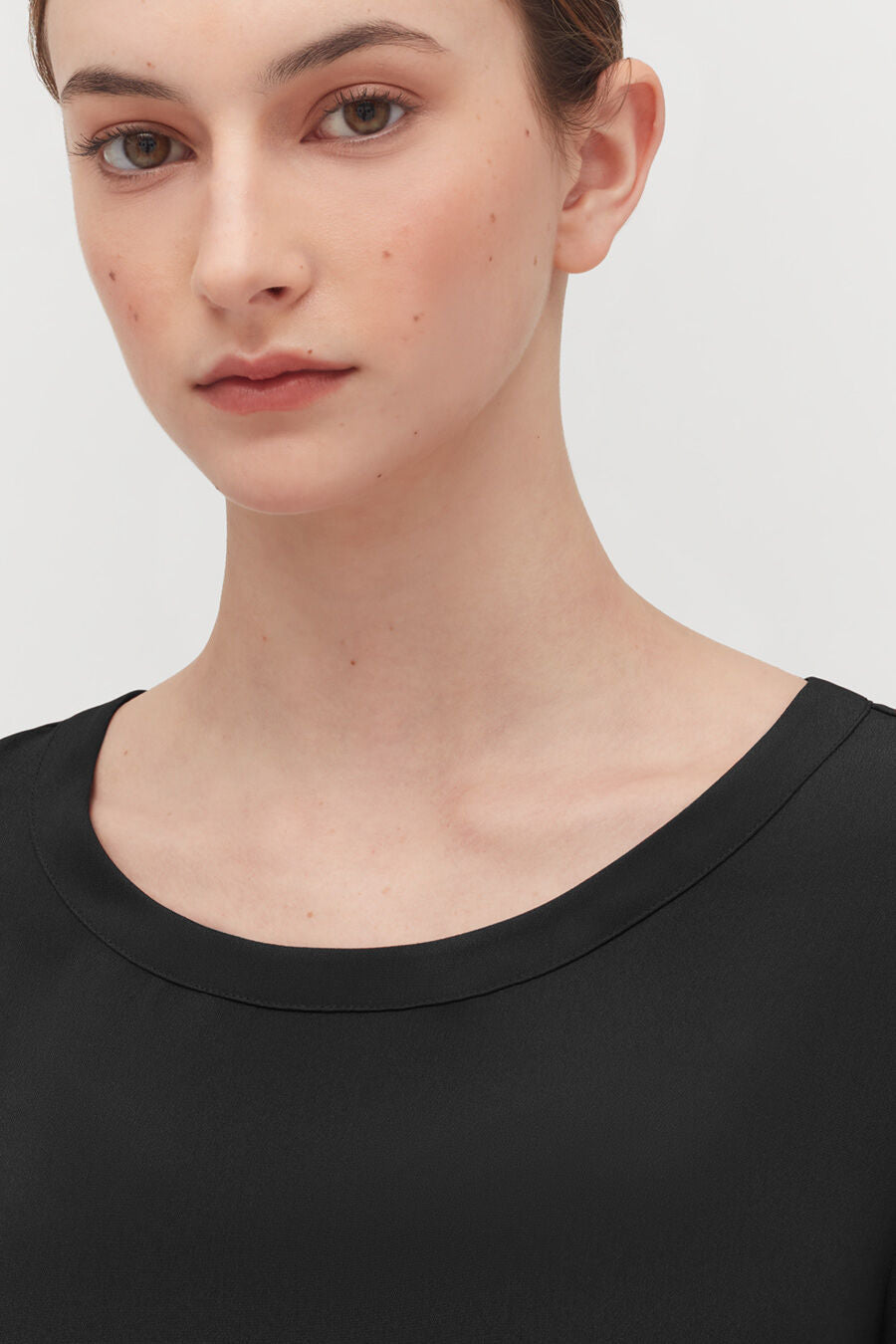 Silk High-Low Tee Woman looking at the camera with a neutral expression.