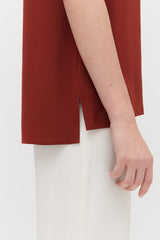 Close-up of a person's arm resting by their side.