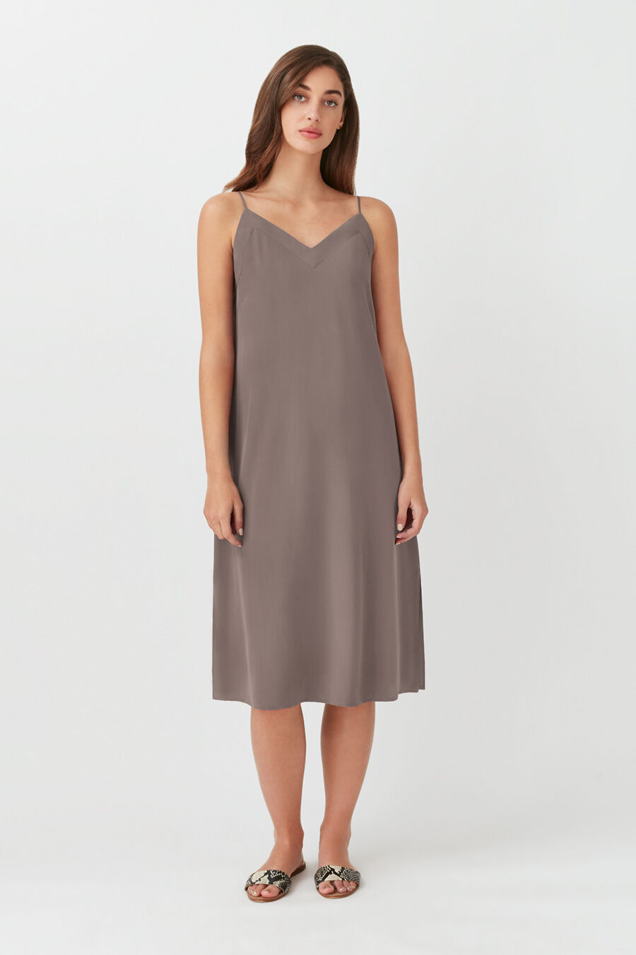 Silk Slip Dress Person standing in a sleeveless knee-length dress and sandals.
