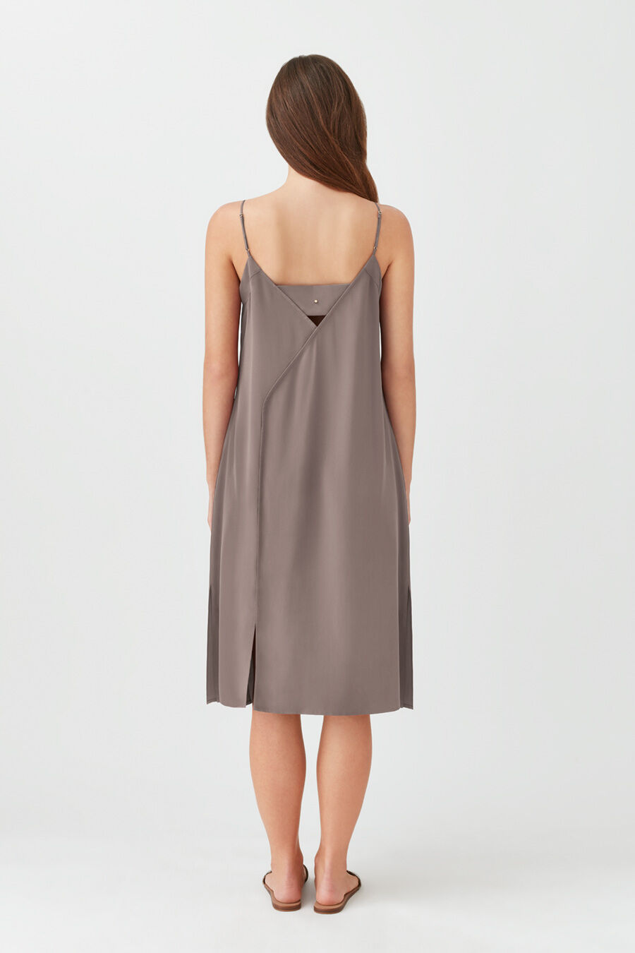 Silk Slip Dress Woman viewed from back wearing a knee-length dress, standing against a plain background.