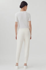 Woman standing with her back towards the camera in a plain outfit.