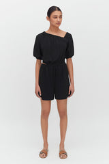 Woman standing in a romper with sandals