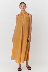 Woman in sleeveless dress standing and looking at camera