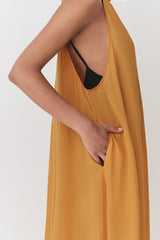 Person holding fabric of a sleeveless top, partial view.