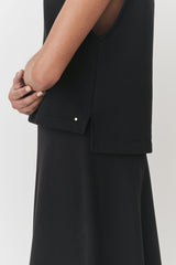 Person standing with one arm hugged around the other arm.