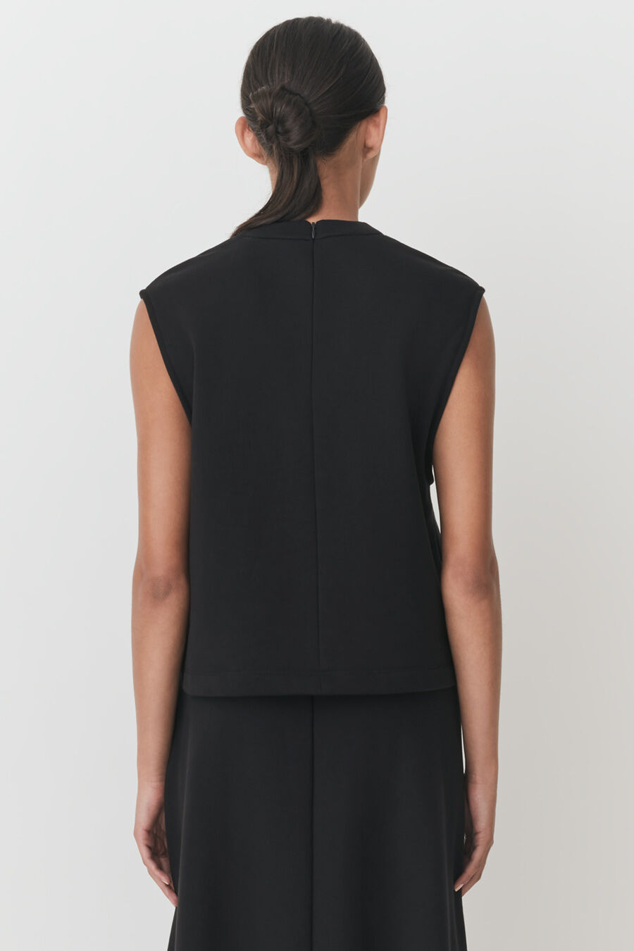 Terry Gusset Neckline Top Woman viewed from behind with hair up in bun and wearing a sleeveless top and skirt.