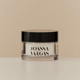 Skincare jar with labeled branding on a plain background.