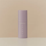 Skincare product container standing on a flat surface.