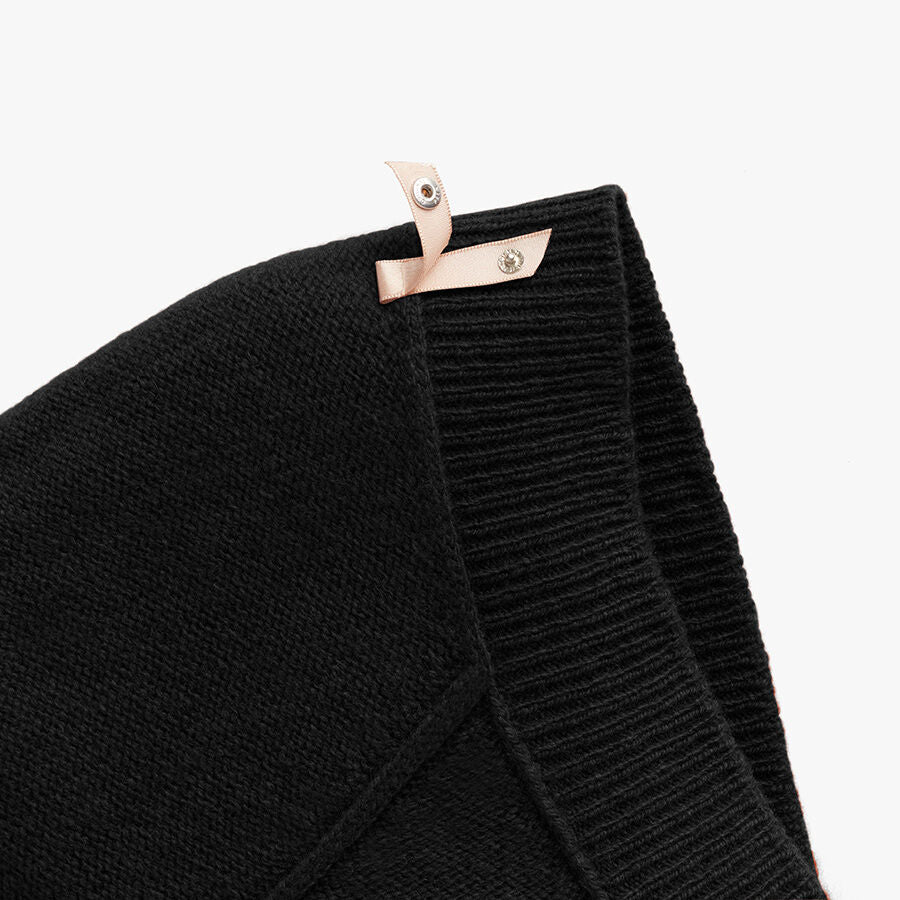 Close-up of a folded scarf with a snap button closure.