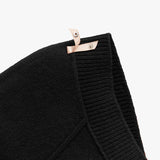 Close-up of a folded scarf with a snap button closure.