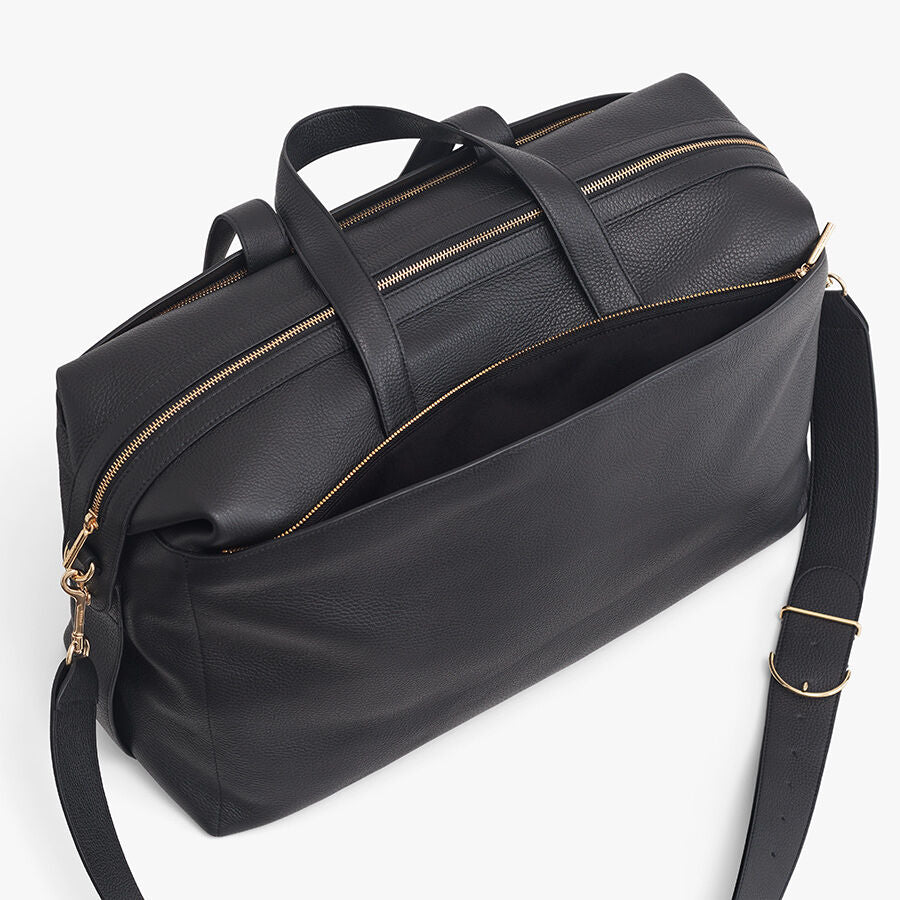 Travel bag with zipper closures and an adjustable shoulder strap.