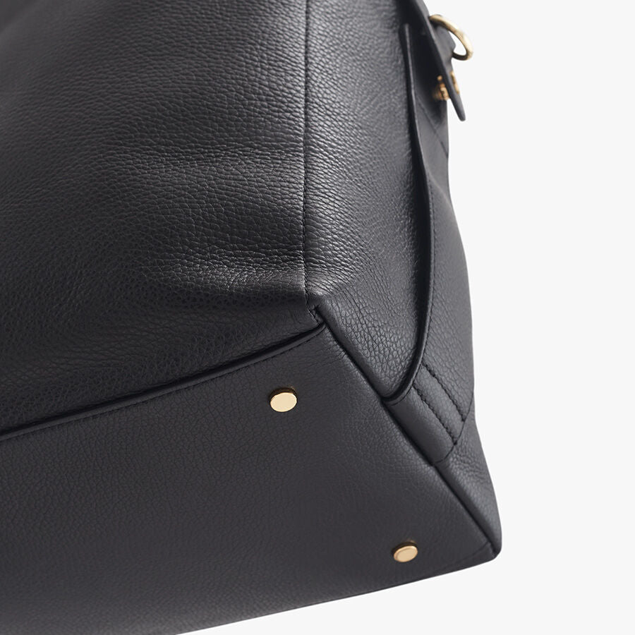 Close-up of a textured handbag with metallic studs.