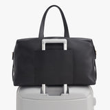 Handbag on top of a suitcase handle