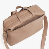 Overhead view of a closed travel bag with a shoulder strap and handles.