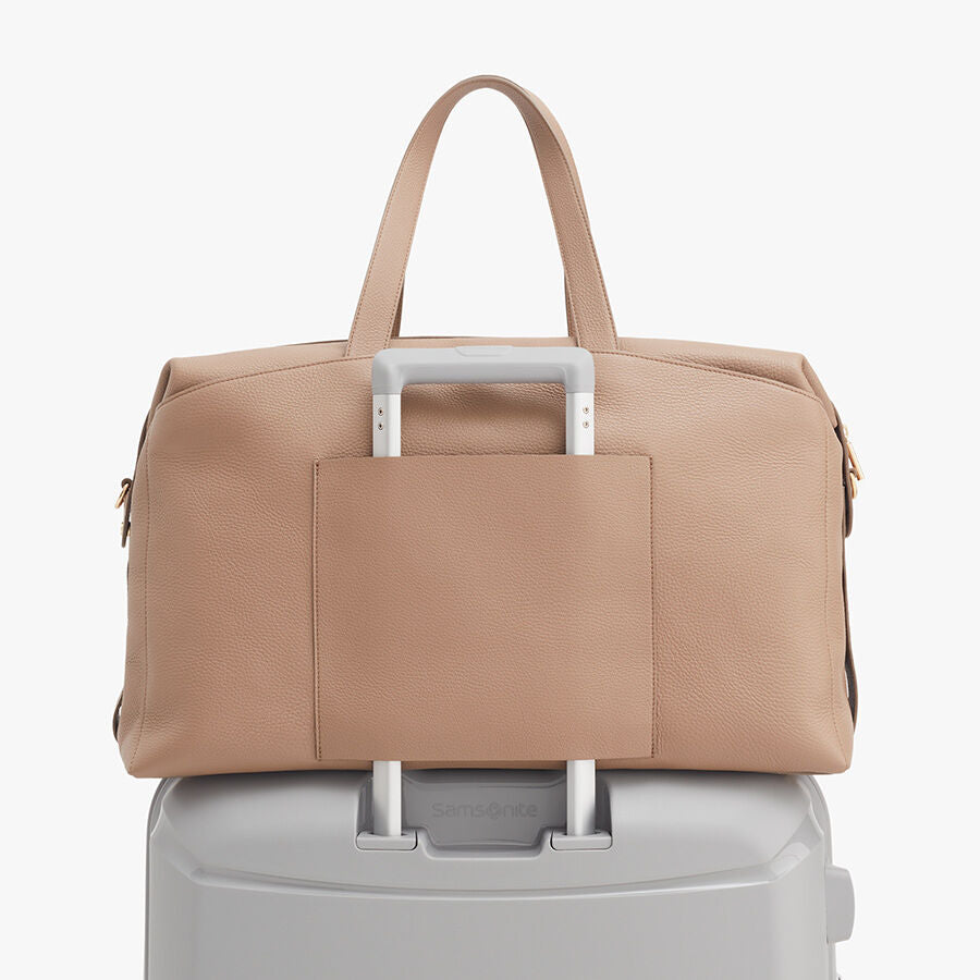 Bag resting on top of a suitcase handle
