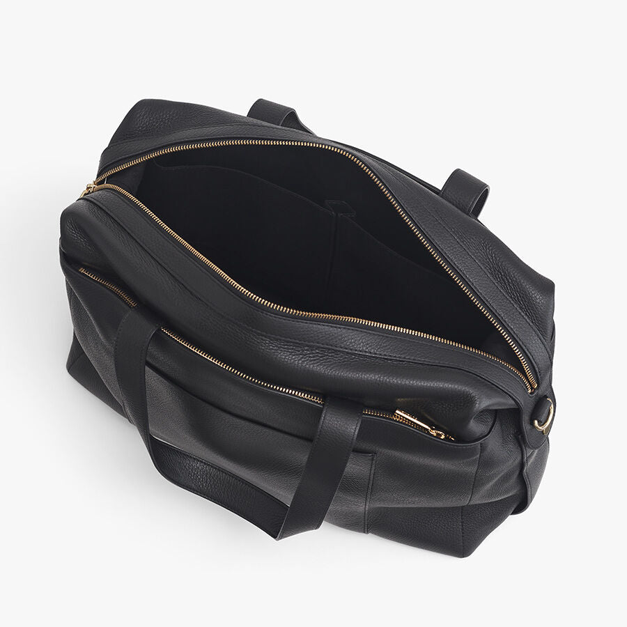 Open weekender travel bag with zippers and handles.