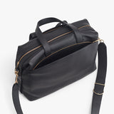 Travel bag with handles and shoulder strap on a plain background