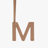 Letter M hanging from a strap.