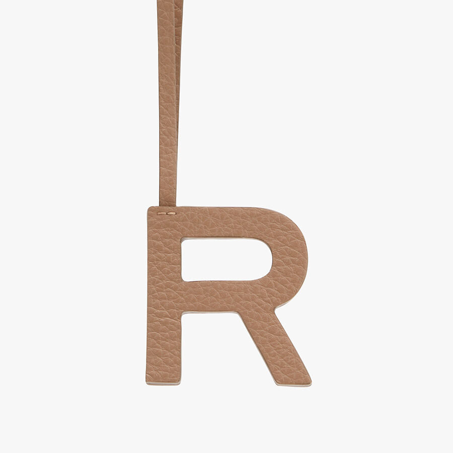 Letter R hanging from a strap.