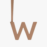 Letter W hanging on a strap against a plain background.