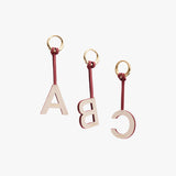 Three keychains with letters A, B, and C attached to rings.