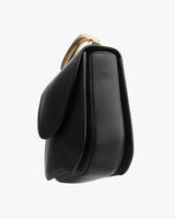 Side view of a closed handbag with a rounded top handle.