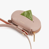 Small round shoulder bag with a leaf sticking out and a brand name embossed on it.