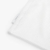 Close-up of a textured fabric with a small tag