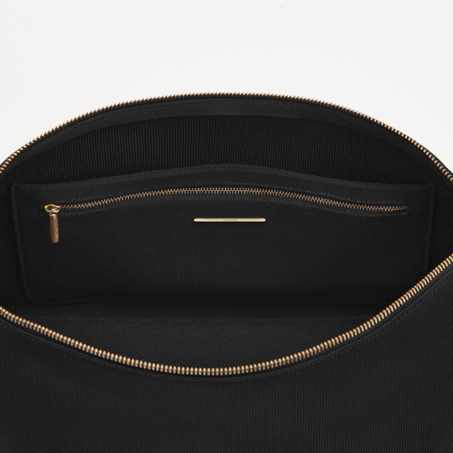 Sling Bag Open bag showing interior with a zipper and a stitched label.