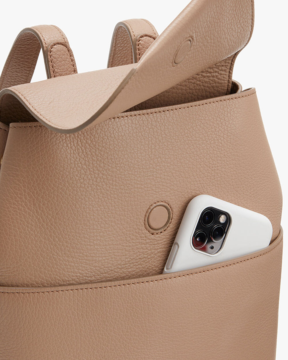 Smartphone peeking out from an open backpack.