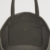 Close-up view of a handbag with a front pocket and brand logo.