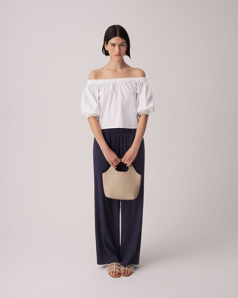 Poplin Off-The-Shoulder Cropped Top Woman in off-shoulder top and pants holding a purse, standing upright.