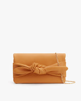 Clutch purse with a knotted design and chain strap, isolated on plain background.