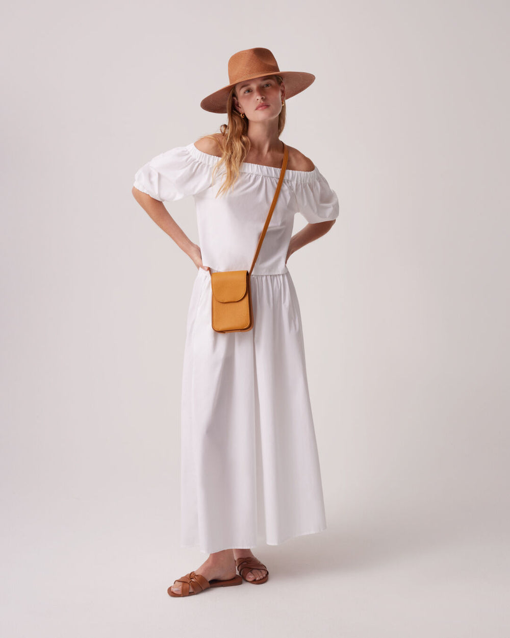 Poplin Gathered Skirt Woman in a dress, hat, and sandals with hands on hips
