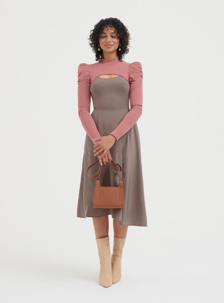 Stretch Scoop Neck Tee Woman standing with a handbag, wearing a long-sleeve dress and boots.