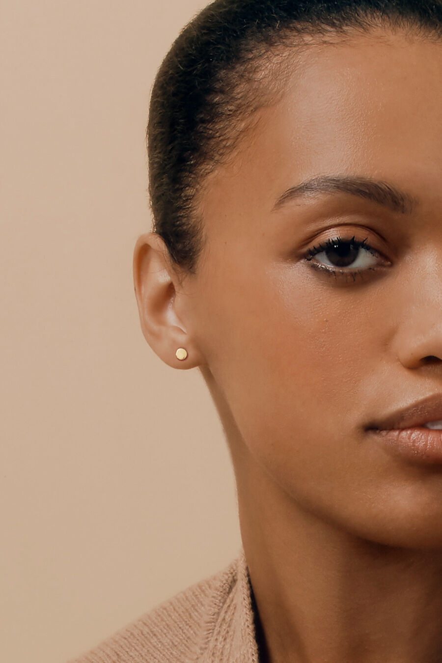 Close-up of a woman looking at the camera, half of her face visible.