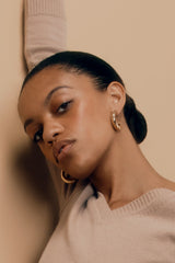 Close-up of a woman with hoop earrings looking at the camera