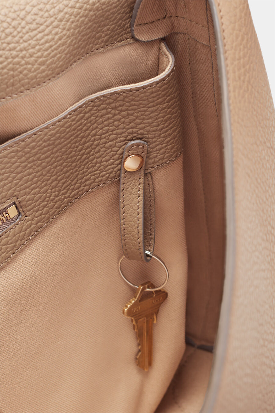 Close-up of a key hanging on a hook inside a bag
