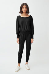 Woman standing in a casual outfit with sneakers.