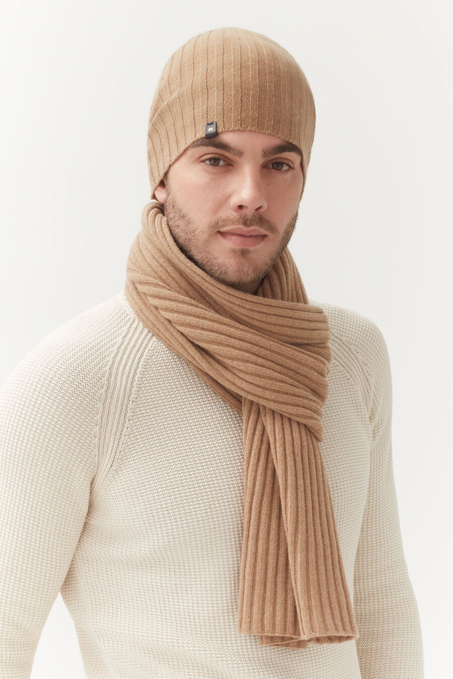 Mens Wool Cashmere Ribbed Scarf Man wearing a beanie and scarf, looking at the camera.