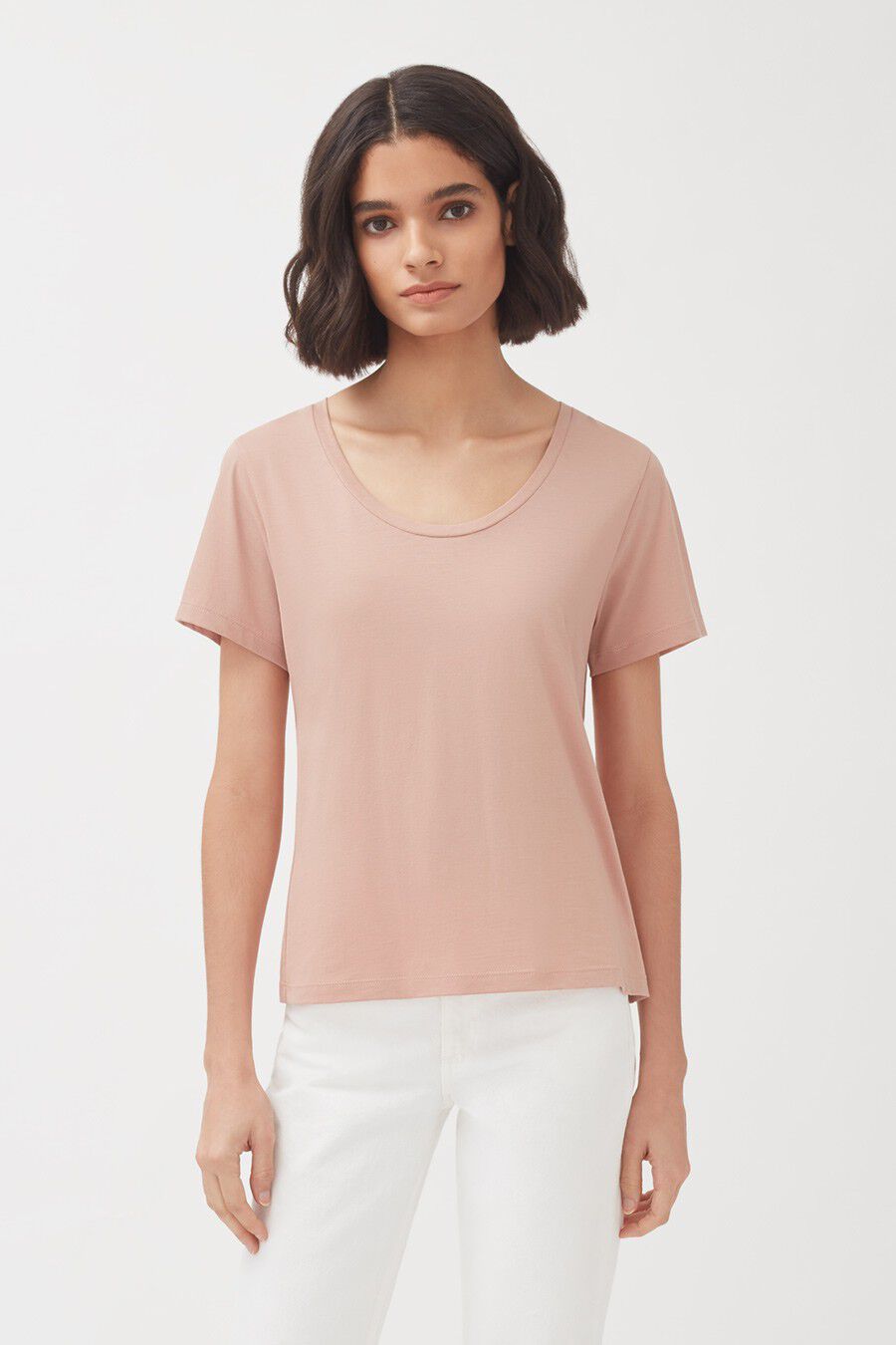 Pima Scoop Neck Tee Woman in a plain t-shirt and pants standing against a white background.